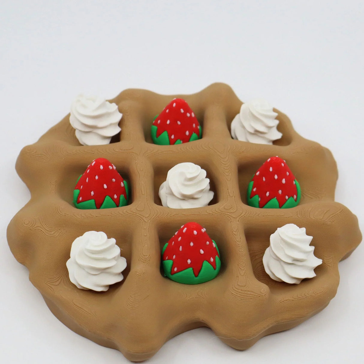 3D printed waffle sensory toy with strawberry and whipped cream pieces on a white background