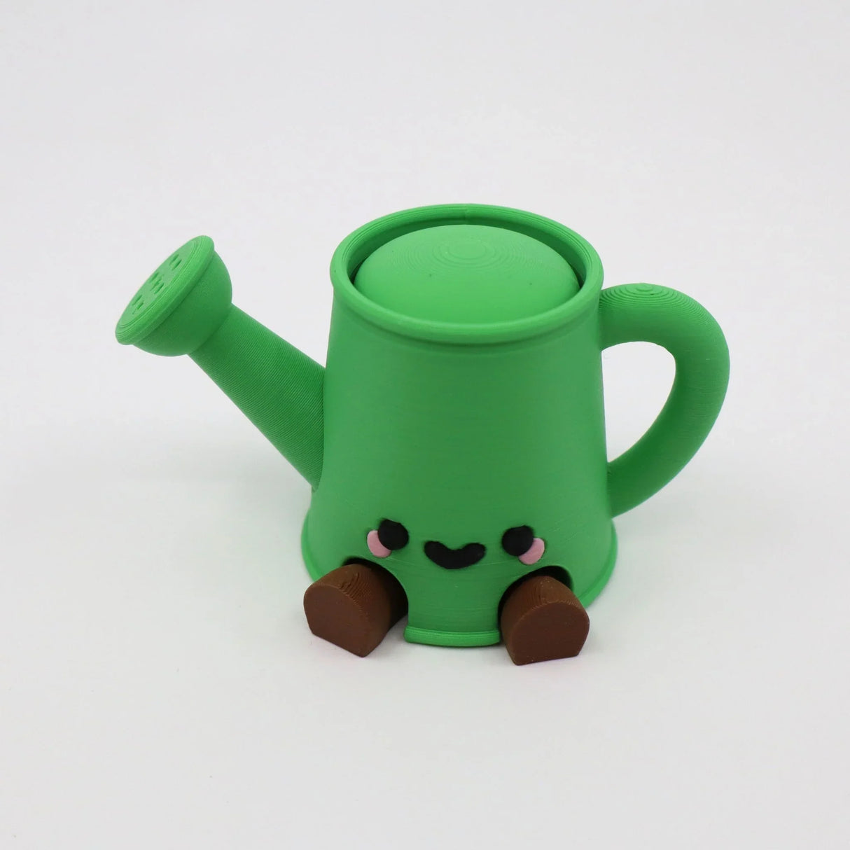 Green 3D printed watering can fidget toy with cute face and brown feet, sensory-friendly design