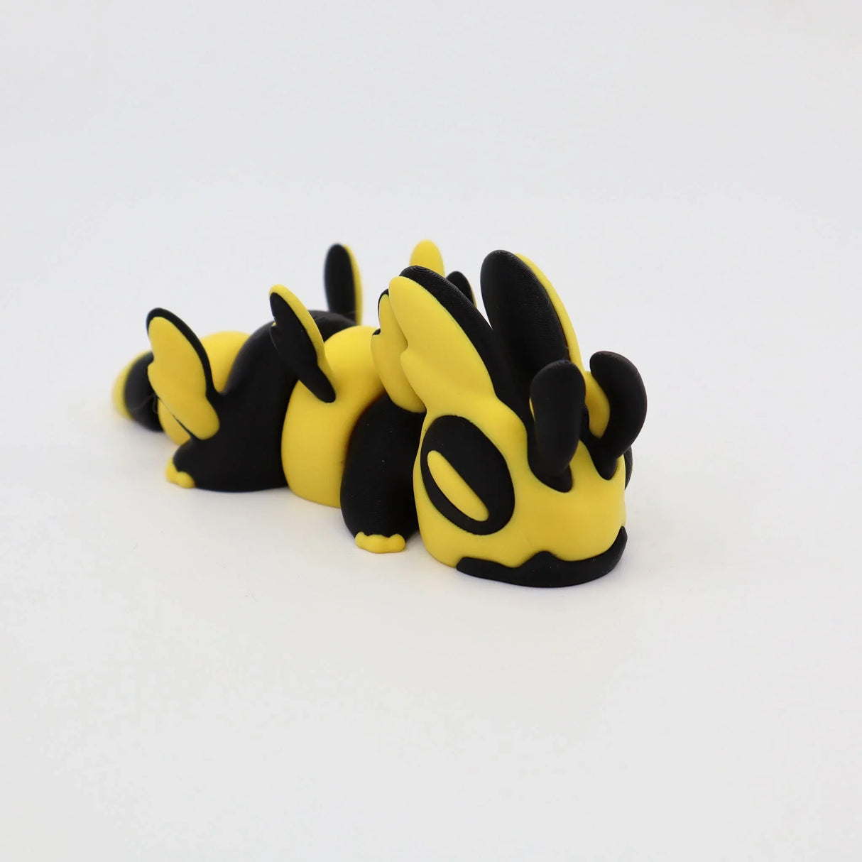 Yellow and black 3D printed sensory animal toy with insect features on white background