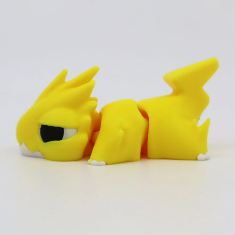 Yellow 3D printed sensory toy dragon with articulated joints, lying on white background