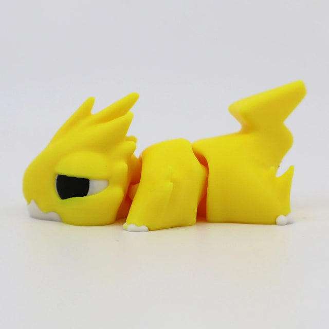 Yellow 3D printed sensory toy dragon with articulated joints, lying on white background