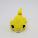 Yellow 3D printed sensory toy dragon with spikes and black eyes on a white background.