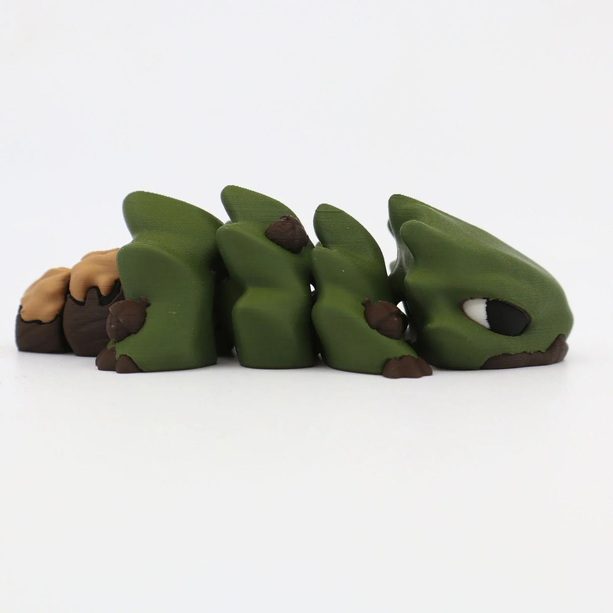 3D printed green and brown sensory fidget toy shaped like a segmented lizard on white background