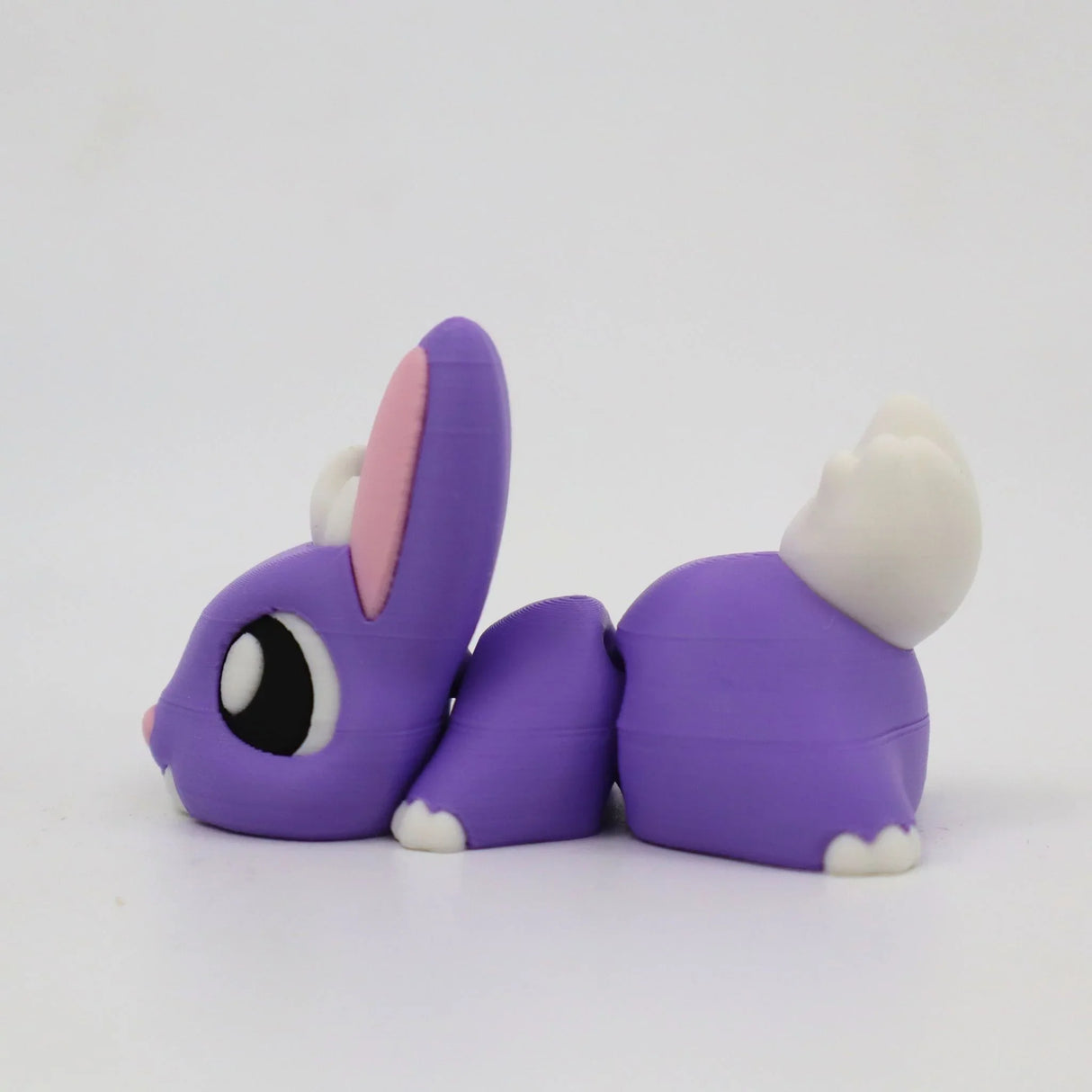 Purple 3D printed rabbit sensory toy with white tail and pink ears on a white background