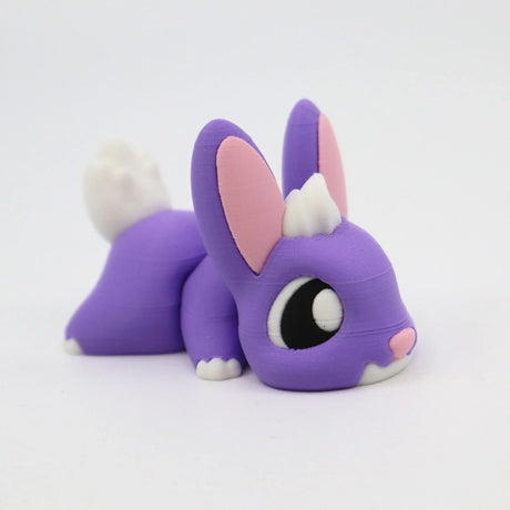 Purple 3D printed sensory bunny toy with white tail, big eyes, and pink ears on white background