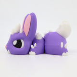 Purple 3D printed sensory bunny toy with white spikes and pink ears on white background
