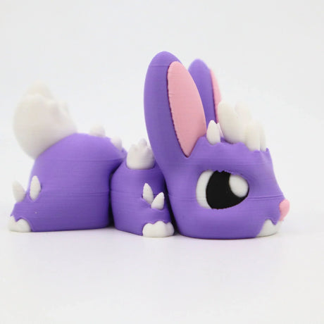 Purple 3D printed sensory toy resembling a cute animal with spikes, large eyes, and pink ears.