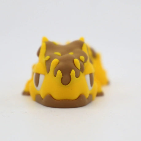 Yellow and brown 3D printed sensory toy resembling a cute animal, on white background.
