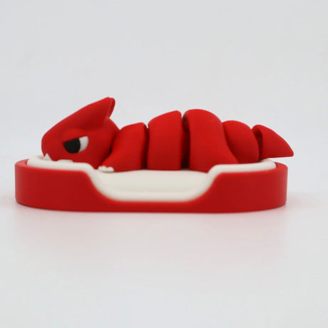 Red 3D printed sensory toy in the shape of a curled creature on a white base