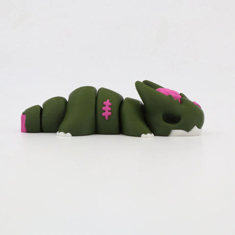 Green 3D printed sensory toy shaped like a segmented dragon with pink and white accents