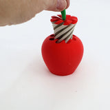Hand twisting green stem on red apple-shaped 3D printed sensory toy with spiral core