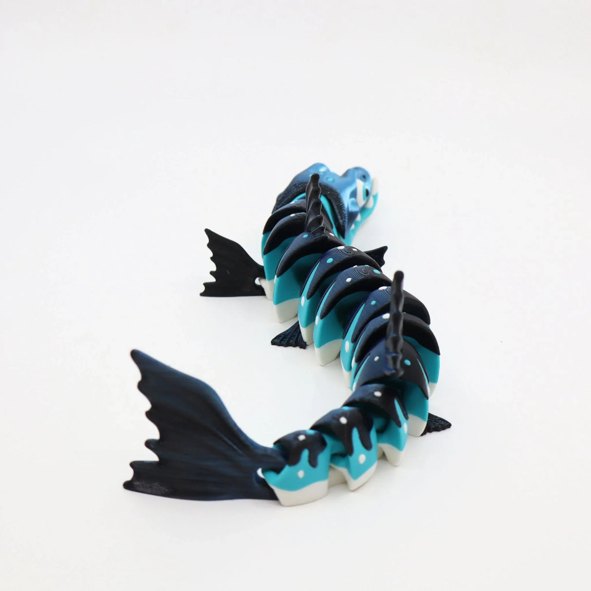 3D printed blue and black flexible barracuda sensory toy with jointed segments