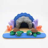 Colorful 3D printed sensory toy set with two green turtles, coral, and a cave scene