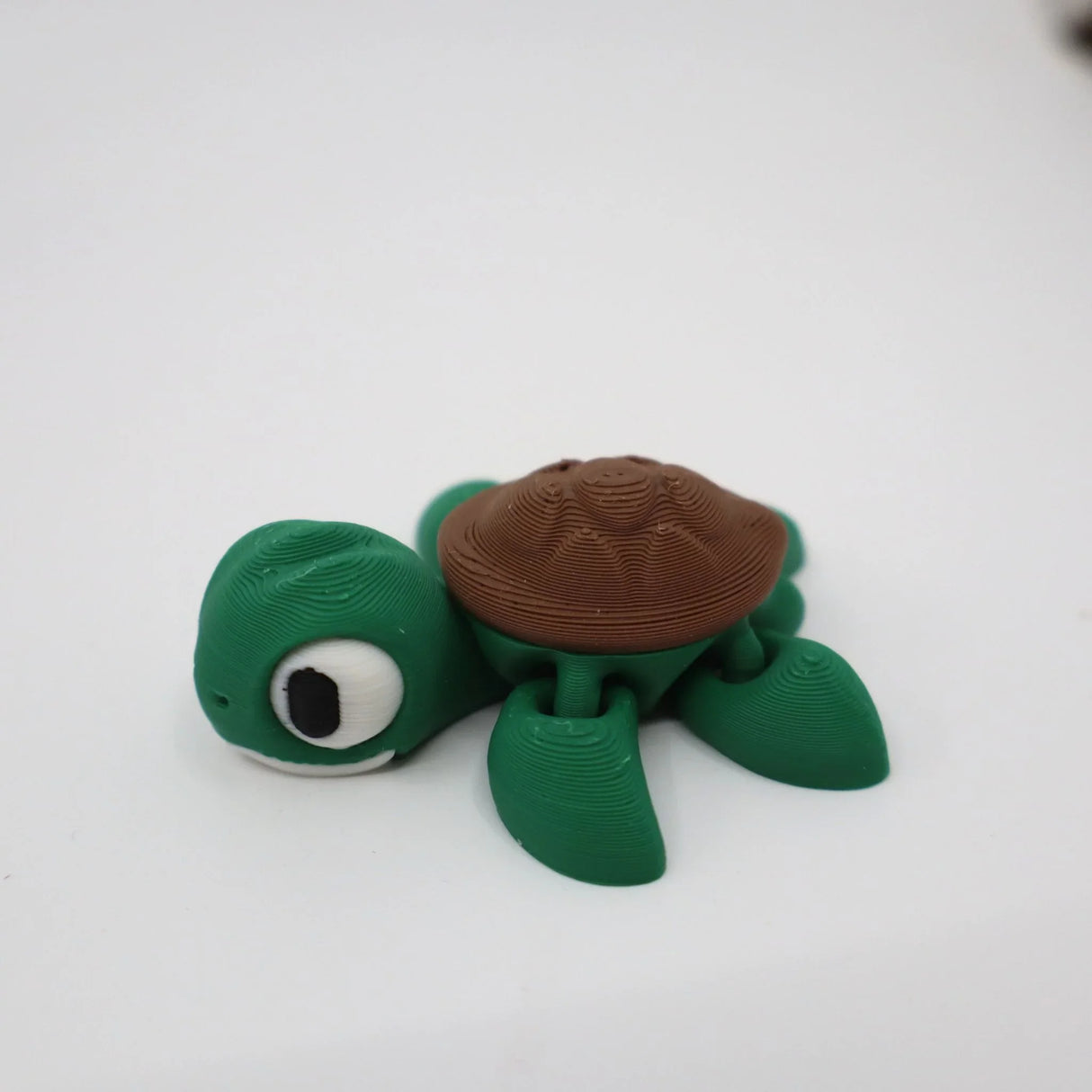 3D printed green turtle sensory toy with brown shell on white background