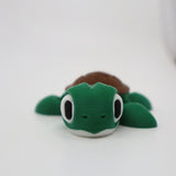 Cute 3D printed green and brown turtle sensory toy with big eyes on white background