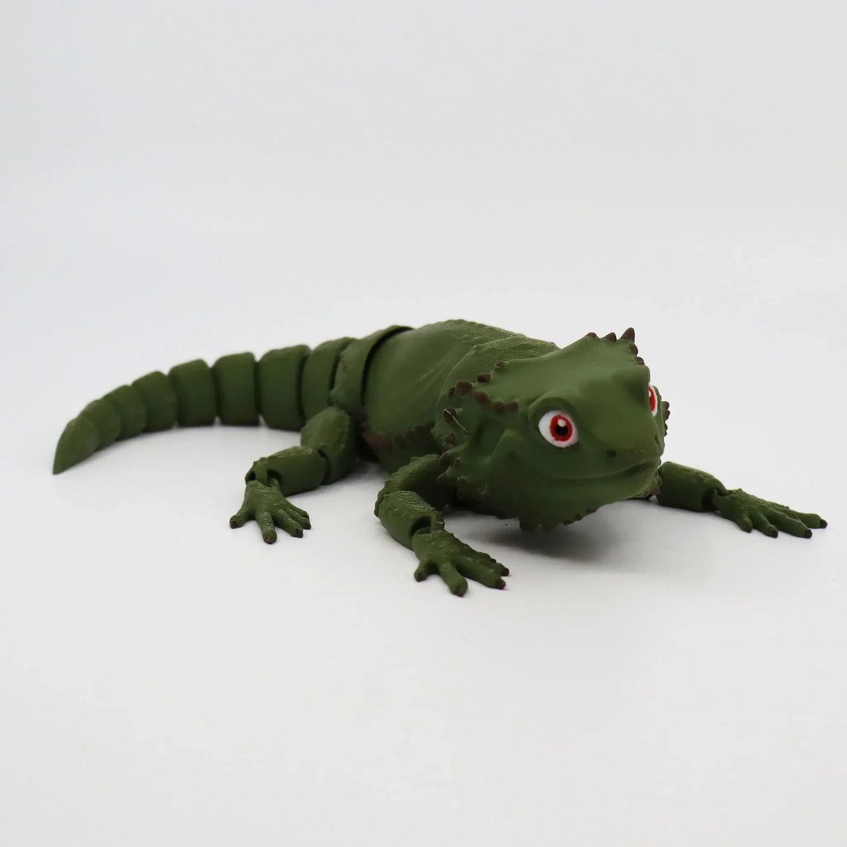 Green 3D printed bearded dragon sensory toy with flexible joints on white background