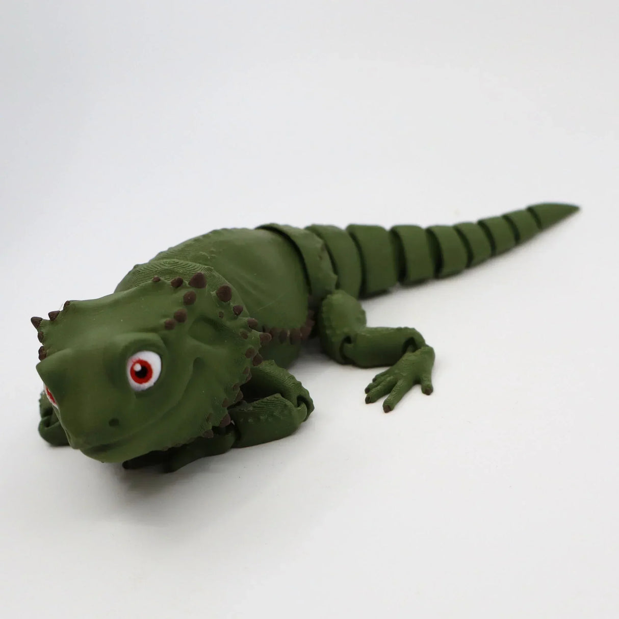 Green 3D printed sensory lizard toy with segmented tail and textured skin on white background.