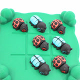 Colorful 3D printed ladybug and beetle sensory toys on green grid for tactile play