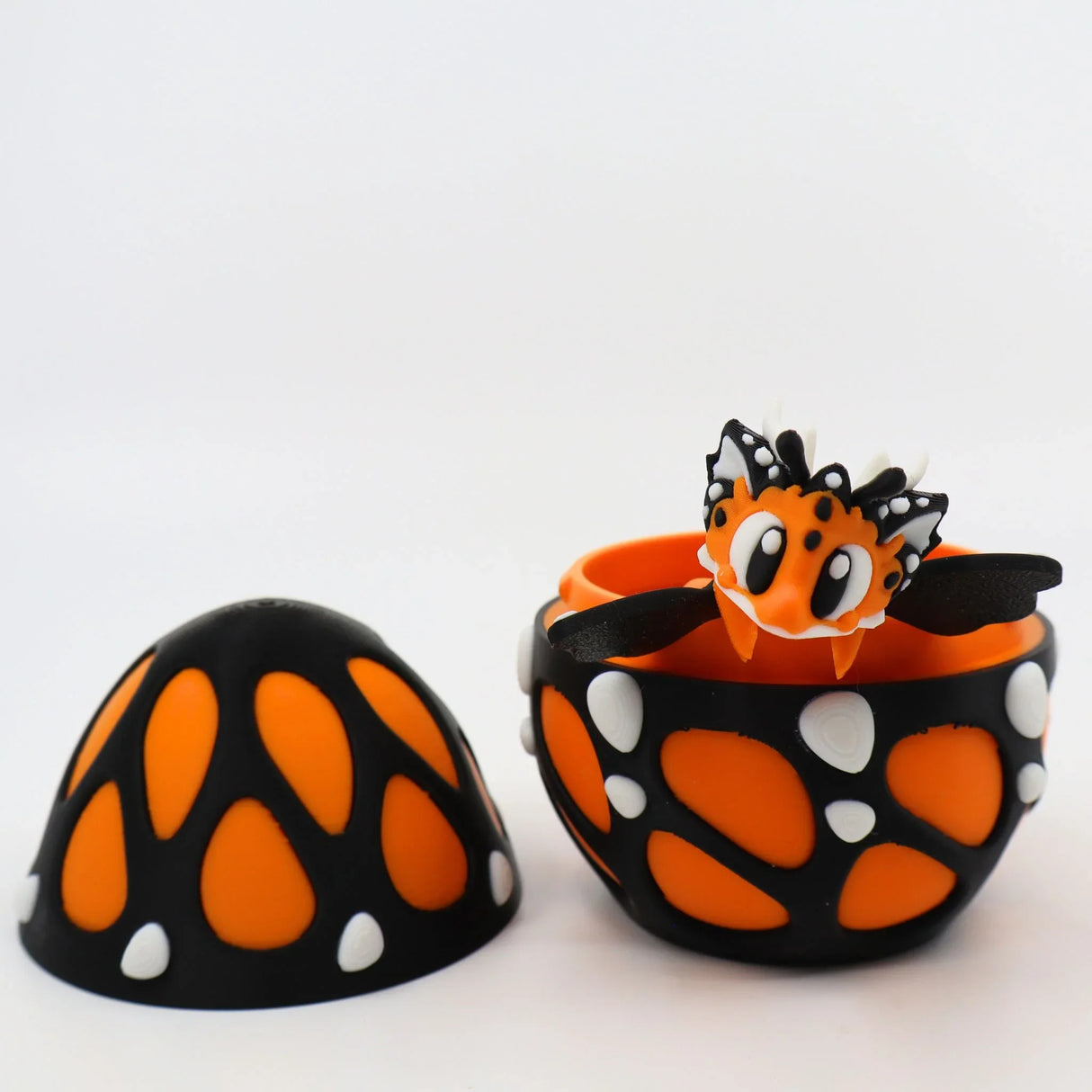3D printed orange and black butterfly sensory toy hatching from patterned egg