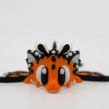 Cute orange and black 3D printed butterfly sensory toy with big eyes on a white background