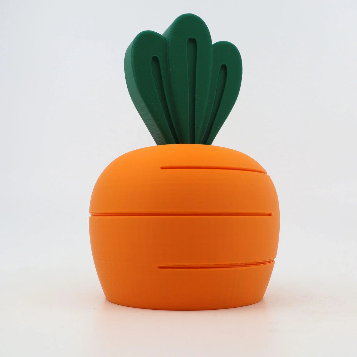 3D printed carrot-shaped sensory toy with green leafy top on white background