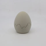 Gray 3D printed sensory egg toy with zigzag crack pattern on white background