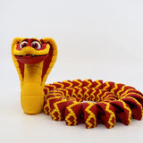 Red and yellow 3D printed cobra sensory toy with articulated body and playful expression