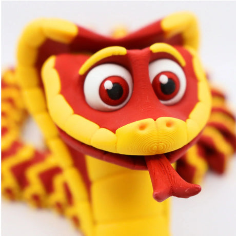 Close-up of a colorful 3D printed red and yellow sensory snake toy with big eyes and a forked tongue.