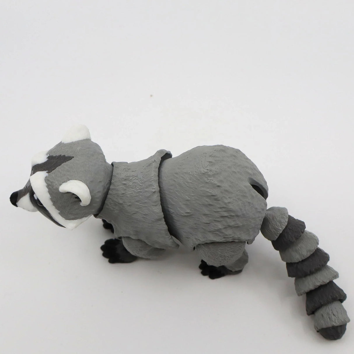 3D printed gray raccoon sensory toy with flexible joints on a white background