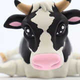 Close-up of a 3D printed black and white cow sensory toy with a pink nose