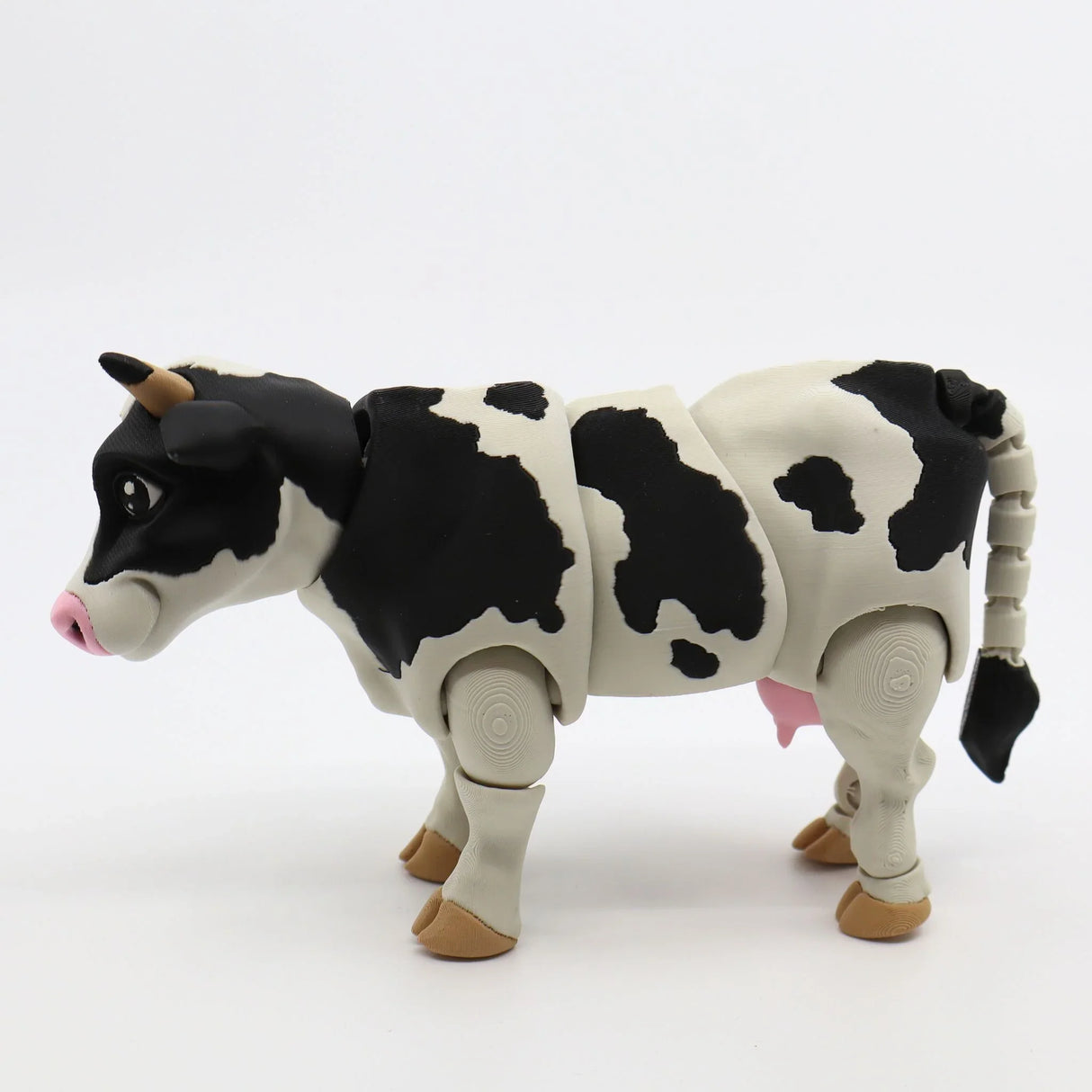 3D printed black and white cow sensory toy with movable limbs on white background