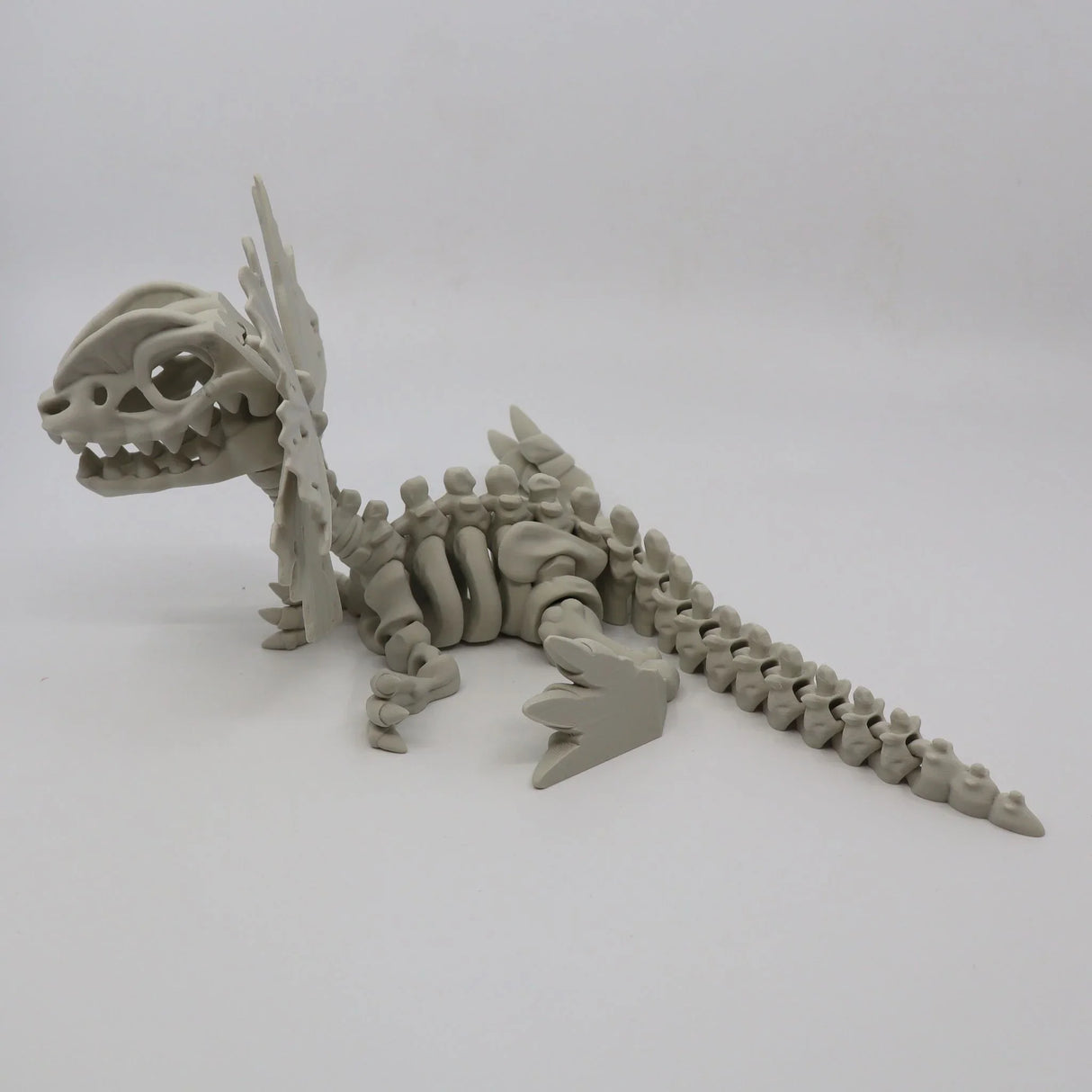 3D printed Dilophosaurus dinosaur skeleton sensory toy on white background
