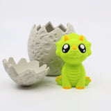 Cute green dinosaur sensory toy sitting beside a cracked 3D printed dinosaur egg