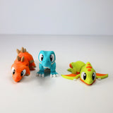 Colorful 3D printed dinosaur sensory toys, orange, blue, and green, on white background