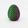Green and purple 3D printed sensory egg toy with spiral grooves on white background
