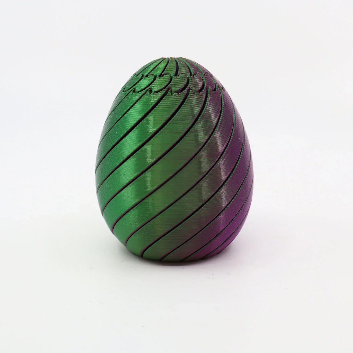 Green and purple 3D printed sensory egg toy with spiral grooves on white background