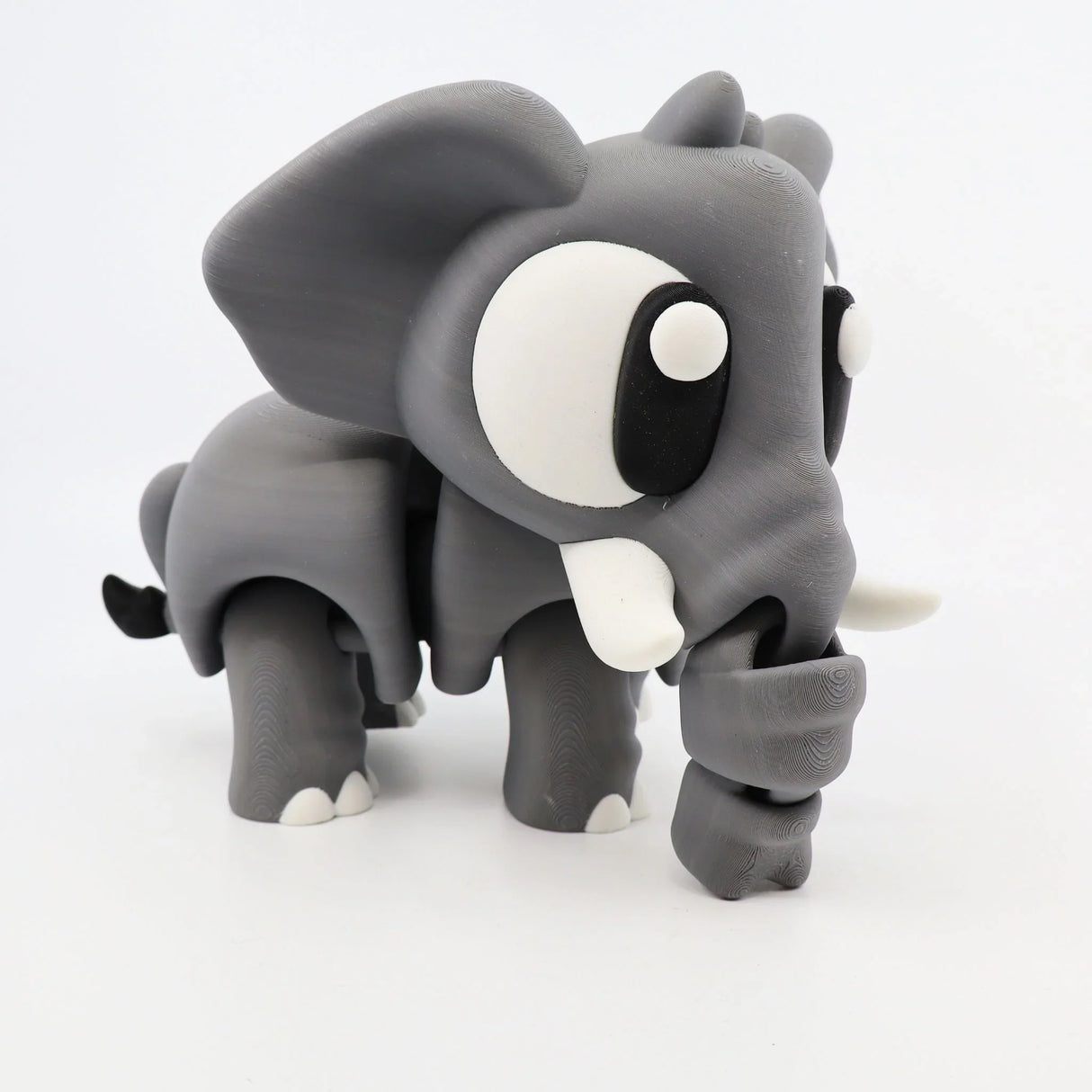 Cute gray 3D printed elephant sensory toy with big eyes and movable trunk on white background