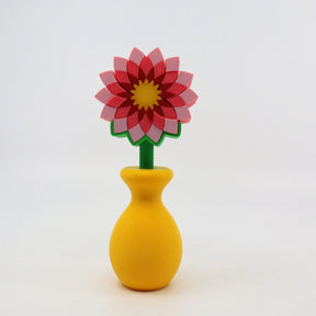 Colorful 3D printed flower sensory toy with pink petals in a yellow vase on white background.