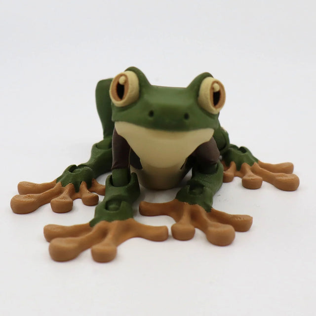 3D printed green and brown frog sensory toy with big eyes on a white background.