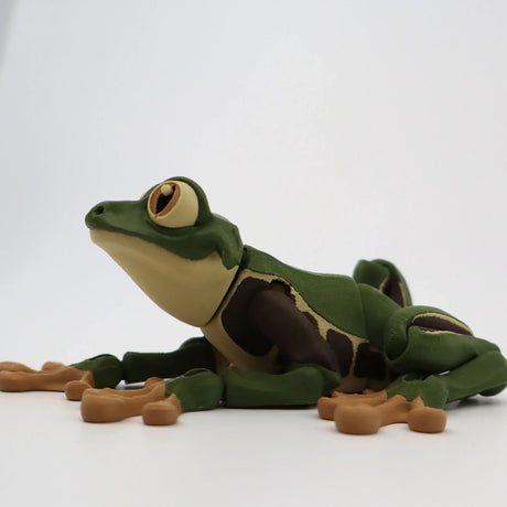 3D printed green and brown frog sensory toy with movable limbs on a white background