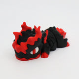 3D printed sensory toy dragon, black and red, with textured scales, on white background