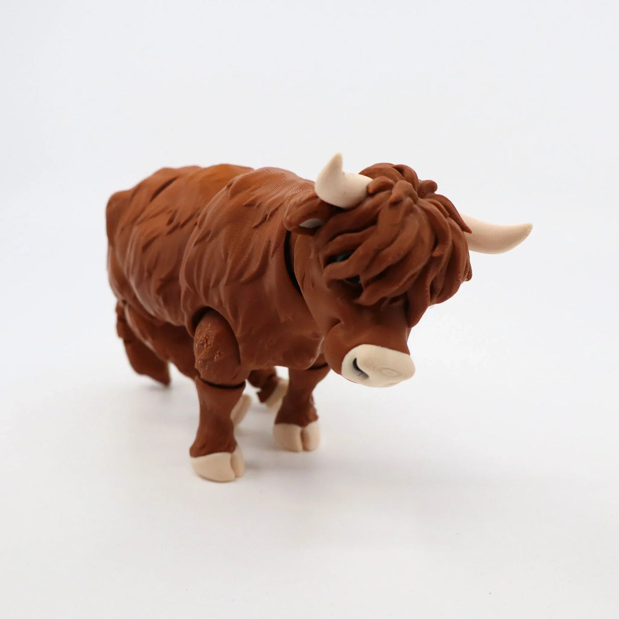3D printed brown highland cow sensory toy with textured fur on white background