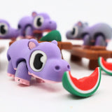 Purple 3D printed hippo sensory toy eating a watermelon slice, playful and colorful design