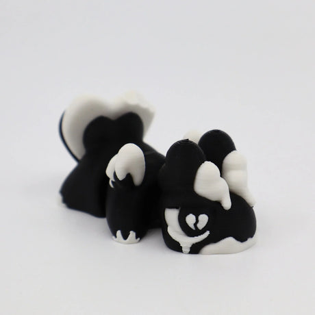 Black and white 3D printed skunk fidget toy with heart design, sensory-friendly for kids