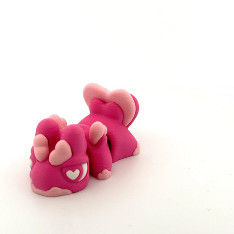 Pink and light pink 3D printed sensory toy in the shape of a cute animal with heart details.