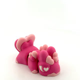 Pink 3D printed sensory toy resembling an animal with heart and paw details on white background