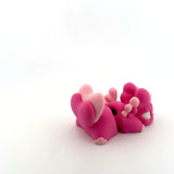 Pink 3D printed sensory toy figures with animal shapes on white background