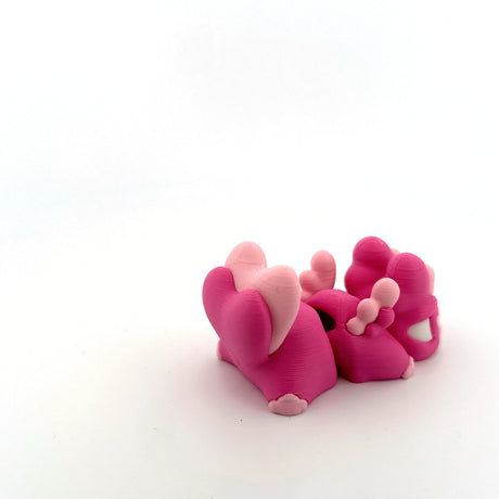 Pink 3D printed sensory toy figures with animal shapes on white background