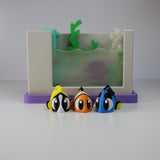 Colorful 3D printed sensory toy fish in front of a small toy aquarium