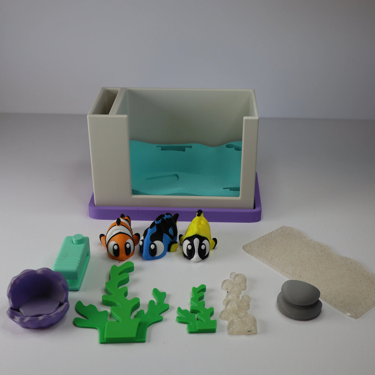 3D printed sensory aquarium playset with colorful toy fish, plants, and tank accessories